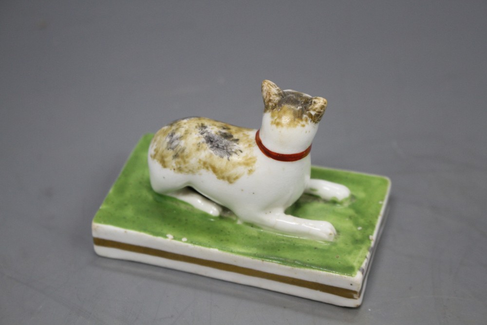 A rare Staffordshire porcelain figure of a recumbent tortoiseshell cat, c.1835-50, L. 7.5cm